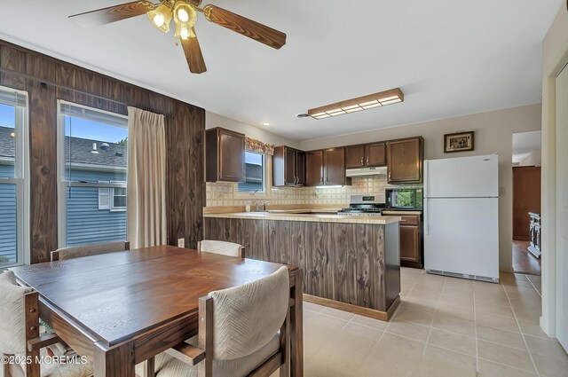 3 Virgin Islands Dr, Toms River, NJ 08757 - kitchen featuring freestanding refrigerator, stainless steel range with gas stovetop, under cabinet range hood, dark brown cabinetry, and decorative backsplash