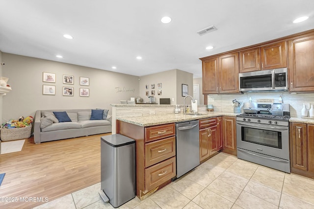 43 Woodledge Ct, Rockaway Twp, NJ 07866 - kitchen with appliances with stainless steel finishes, a sink, a peninsula, open floor plan, and light stone counters