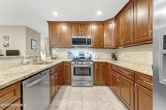 43 Woodledge Ct, Rockaway Twp, NJ 07866 - kitchen featuring stainless steel appliances, a sink, backsplash, light stone countertops, and brown cabinetry