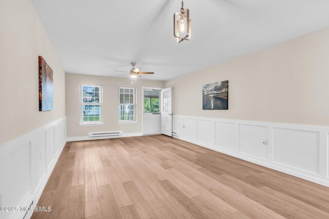28 Mill Rd Unit B, Whiting, NJ 08759 - unfurnished living room featuring baseboard heating, ceiling fan, light wood-style floors, a decorative wall, and wainscoting