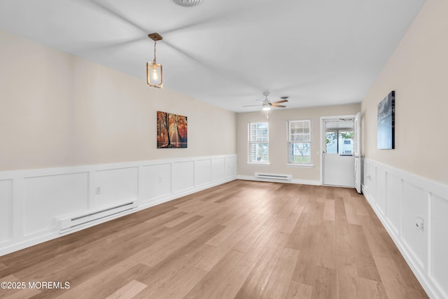 28 Mill Rd Unit B, Whiting, NJ 08759 - spare room featuring baseboard heating, a wainscoted wall, ceiling fan, light wood-style floors, and a decorative wall