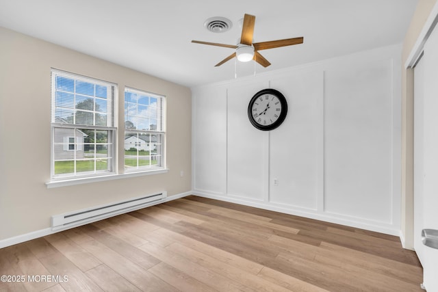 28 Mill Rd Unit B, Whiting, NJ 08759 - empty room featuring a baseboard heating unit, light wood-style floors, ceiling fan, and a decorative wall