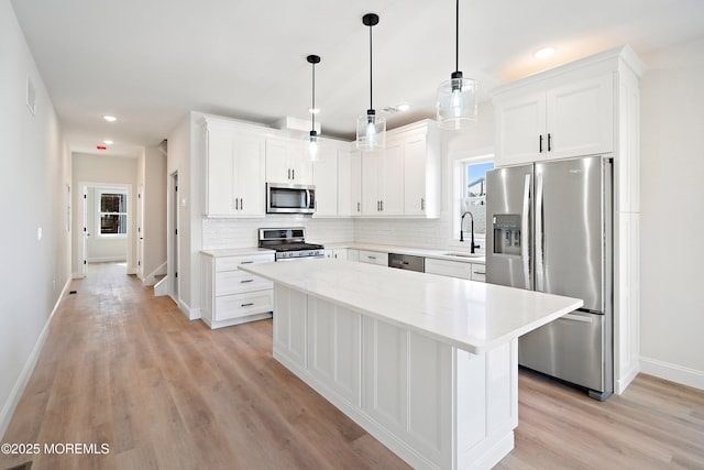 51 Sampson Ave, Seaside Heights, NJ 08751 - kitchen featuring appliances with stainless steel finishes, baseboards, backsplash, a kitchen island, and healthy amount of natural light