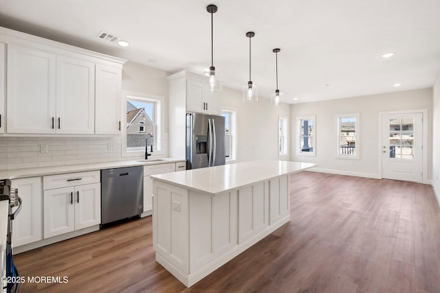 51 Sampson Ave, Seaside Heights, NJ 08751 - kitchen with stainless steel appliances, a sink, light wood-type flooring, decorative backsplash, and white cabinetry