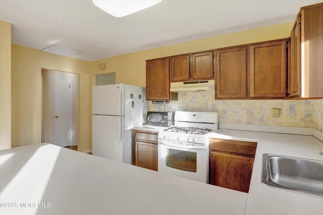 31 Togo Rd, Toms River, NJ 08757 - kitchen with white appliances, under cabinet range hood, brown cabinetry, light countertops, and a sink