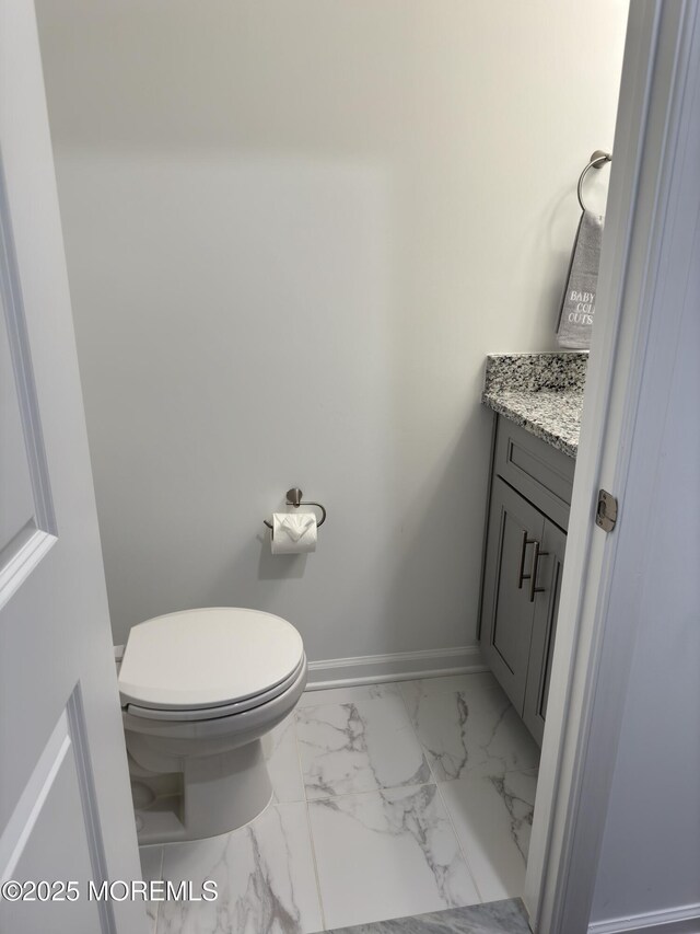 300 Prestige Rd, Brick, NJ 08723 - half bathroom featuring vanity, marble look tile flooring, baseboards, and toilet