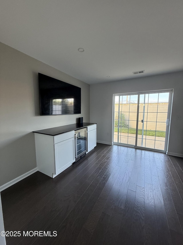 300 Prestige Rd, Brick, NJ 08723 - unfurnished living room featuring beverage cooler, baseboards, and dark wood-style flooring