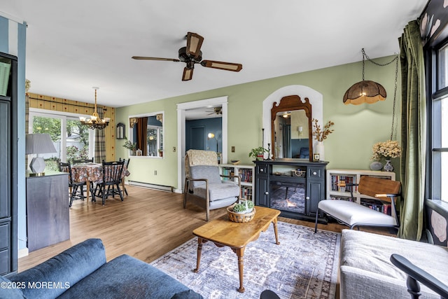 930 Devon St, Forked River, NJ 08731 - living room featuring baseboard heating, a chandelier, ceiling fan, wood finished floors, and a glass covered fireplace