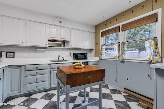 930 Devon St, Forked River, NJ 08731 - kitchen with black microwave, a sink, a baseboard heating unit, light countertops, and backsplash