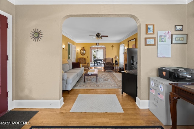 10 Fulton St, Freehold, NJ 07728 - living area featuring arched walkways, a ceiling fan, light wood-style floors, crown molding, and baseboards