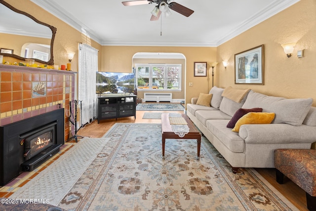 10 Fulton St, Freehold, NJ 07728 - living room with ornamental molding, a fireplace, radiator heating unit, a ceiling fan, and wood finished floors