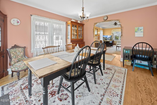 10 Fulton St, Freehold, NJ 07728 - dining area featuring crown molding, healthy amount of natural light, a chandelier, arched walkways, and light wood-style floors