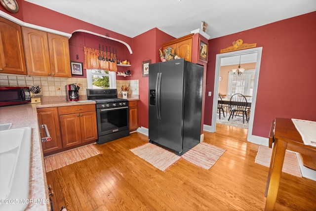 10 Fulton St, Freehold, NJ 07728 - kitchen with stainless steel appliances, light wood-style flooring, light countertops, tasteful backsplash, and brown cabinetry