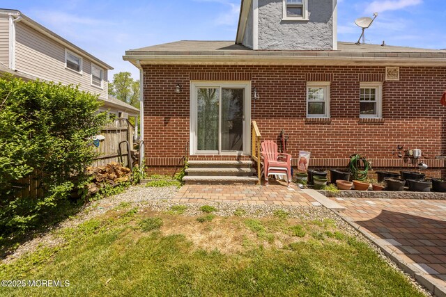 10 Fulton St, Freehold, NJ 07728 - back of house with entry steps, brick siding, a patio area, and a shingled roof