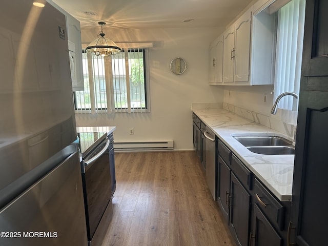 12 Medford Ct, Red Bank, NJ 07701 - kitchen featuring stainless steel appliances, a sink, a baseboard heating unit, white cabinetry, and light stone counters