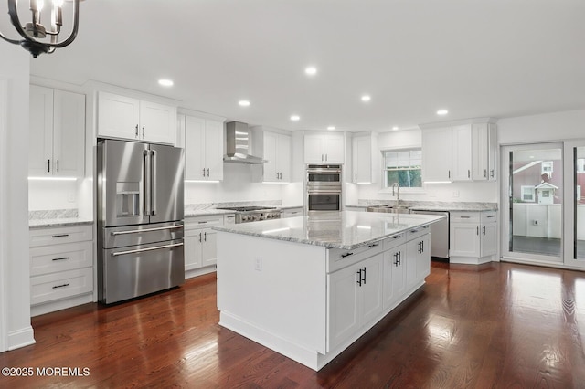 18 Neptune Pl, North Middletown, NJ 07748 - kitchen featuring appliances with stainless steel finishes, wall chimney exhaust hood, a sink, white cabinets, and a chandelier