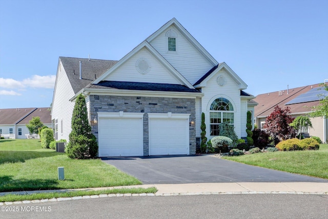 7 Jester Ct, Monroe, NJ 08831 - traditional-style home featuring asphalt driveway, stone siding, a front yard, a garage, and central AC
