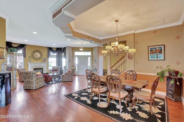 7 Jester Ct, Monroe, NJ 08831 - dining room featuring a chandelier, ornamental molding, wood finished floors, a warm lit fireplace, and baseboards