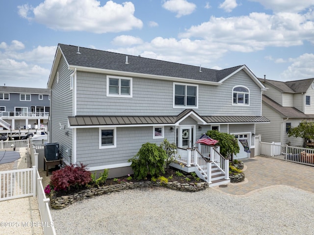 1498 Paul Blvd, Manahawkin, NJ 08050 - view of front of house featuring a standing seam roof, decorative driveway, roof with shingles, metal roof, and central AC