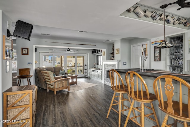 1498 Paul Blvd, Manahawkin, NJ 08050 - dining space featuring dark wood finished floors, a ceiling fan, a fireplace, french doors, and bar area