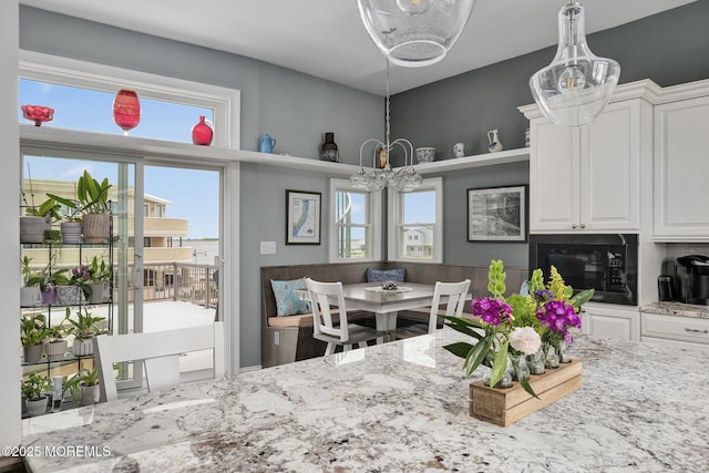1498 Paul Blvd, Manahawkin, NJ 08050 - kitchen with white cabinets, light stone countertops, black microwave, and a chandelier