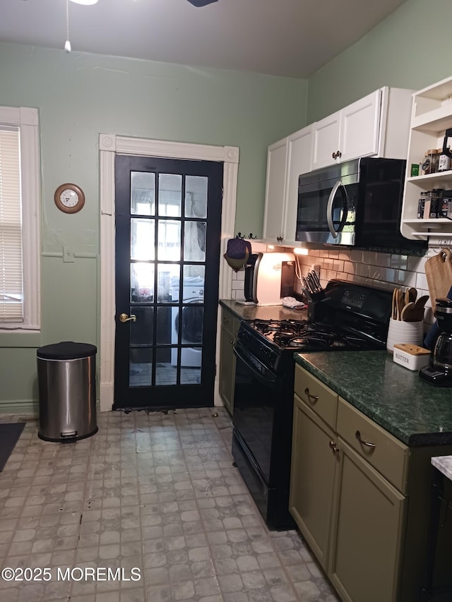 kitchen featuring black gas stove, stainless steel microwave, open shelves, backsplash, and plenty of natural light
