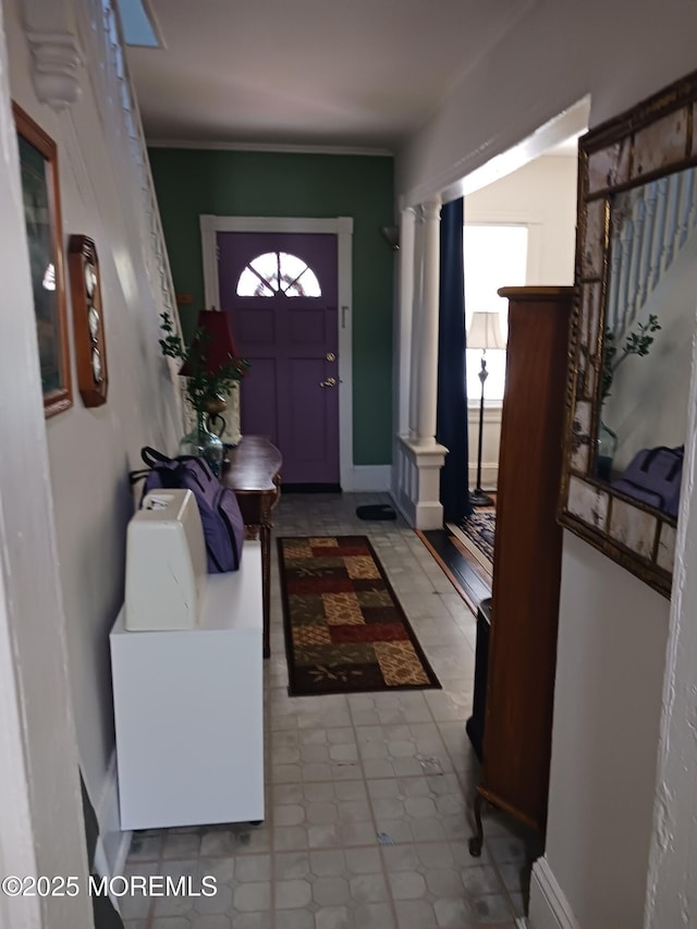 entryway with decorative columns and tile patterned floors