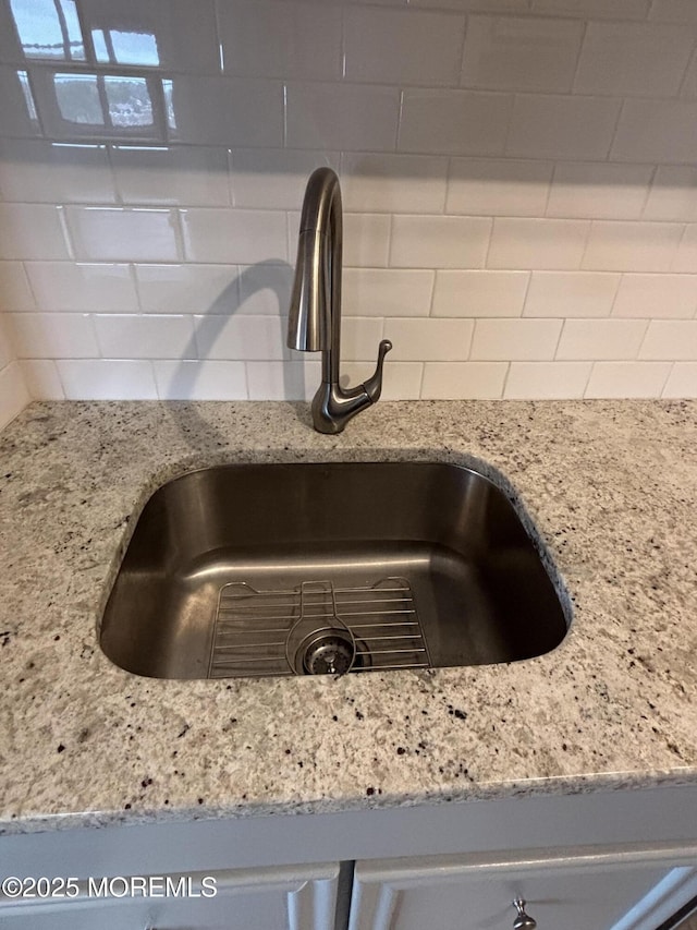 28 Riverside Ave Unit 9G, Red Bank, NJ 07701 - kitchen view of a sink, backsplash, and light stone counters