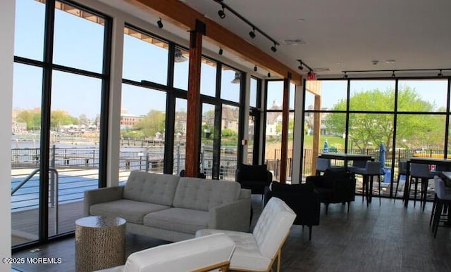 28 Riverside Ave Unit 9G, Red Bank, NJ 07701 - living area with a wall of windows, dark wood-type flooring, rail lighting, and a towering ceiling