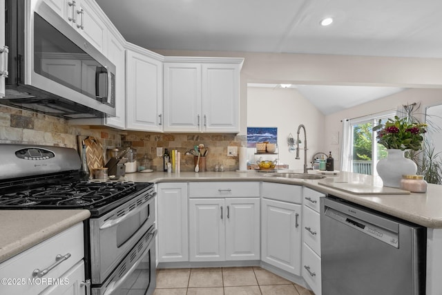 33 Red Maple Dr, Brick, NJ 08724 - kitchen featuring stainless steel appliances, a sink, decorative backsplash, a peninsula, and lofted ceiling