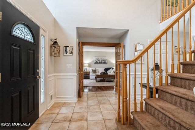 81 W Shenendoah Rd, Howell, NJ 07731 - foyer entrance with stairs, a decorative wall, light tile patterned floors, a wainscoted wall, and a high ceiling