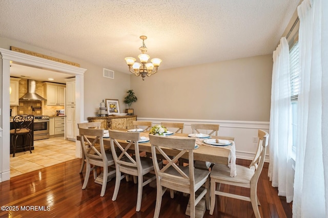 81 W Shenendoah Rd, Howell, NJ 07731 - dining room featuring a chandelier, a textured ceiling, wainscoting, and light wood finished floors