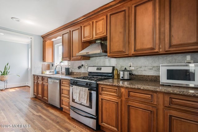 110 W 4th St, Howell, NJ 07731 - kitchen with stainless steel appliances, range hood, brown cabinetry, and ornamental molding