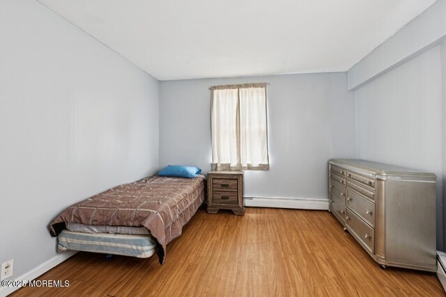 110 W 4th St, Howell, NJ 07731 - bedroom with a baseboard heating unit and wood finished floors