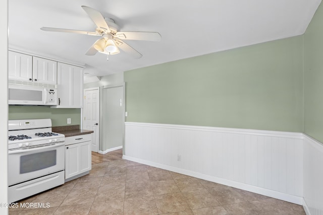 18 Hampton Rd, Howell, NJ 07731 - kitchen featuring white appliances, dark countertops, white cabinetry, a ceiling fan, and a wainscoted wall