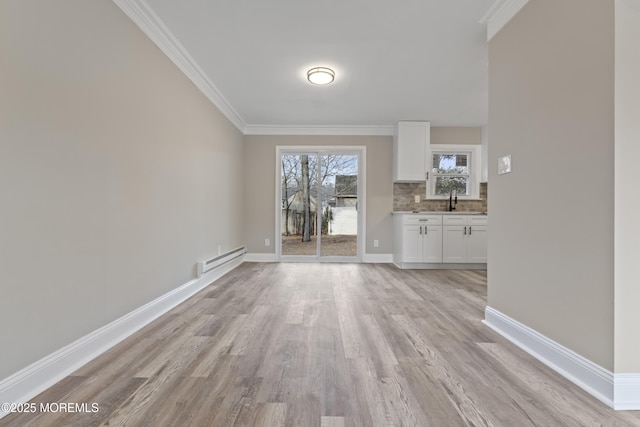2A Primrose Ln, Jackson, NJ 08527 - unfurnished dining area featuring a baseboard radiator, ornamental molding, light wood-style flooring, baseboards, and a sink