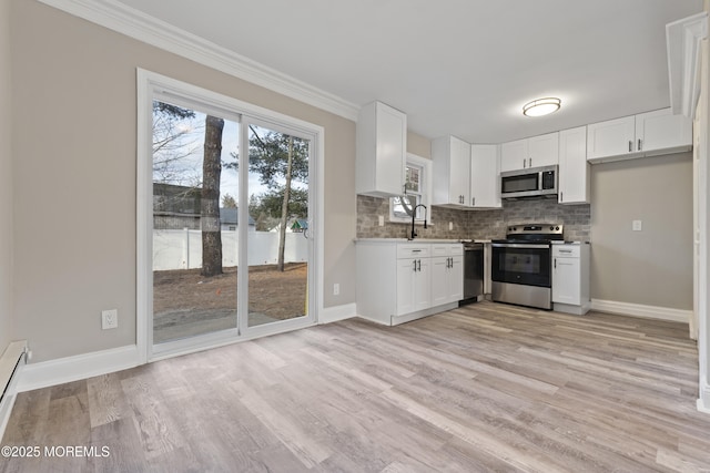 2A Primrose Ln, Jackson, NJ 08527 - kitchen with stainless steel appliances, backsplash, white cabinetry, ornamental molding, and light wood-type flooring
