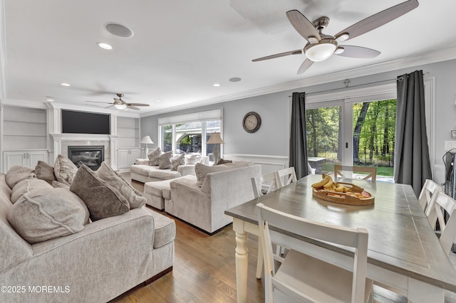 25 Briar Hill Dr, Manalapan, NJ 07726 - living area featuring a ceiling fan, crown molding, a fireplace, a wainscoted wall, and wood finished floors
