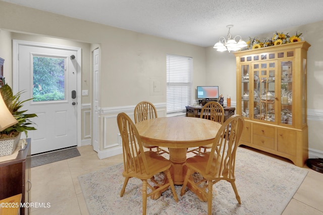 104 Deerfoot Way, Jackson, NJ 08527 - dining area with a chandelier, light tile patterned flooring, wainscoting, a decorative wall, and a textured ceiling