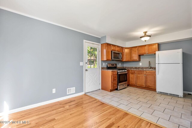 7 Beechwood Ave, Keansburg, NJ 07734 - kitchen featuring appliances with stainless steel finishes, a sink, baseboards, light wood-style flooring, and brown cabinetry