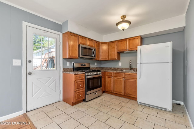 7 Beechwood Ave, Keansburg, NJ 07734 - kitchen featuring stainless steel appliances, a sink, brown cabinetry, and baseboards