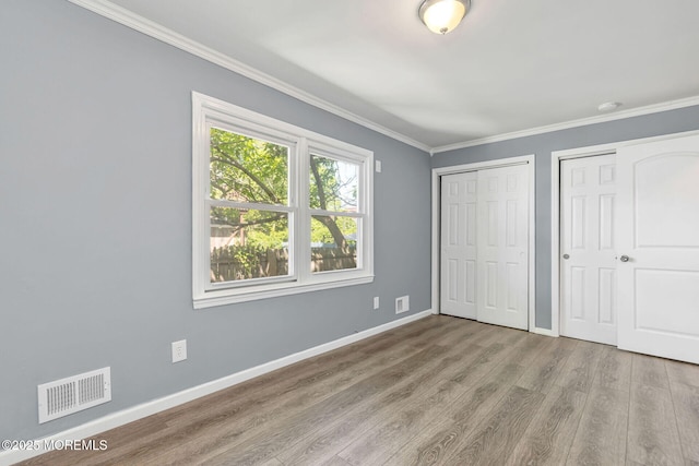 7 Beechwood Ave, Keansburg, NJ 07734 - unfurnished bedroom featuring two closets, ornamental molding, baseboards, and wood finished floors