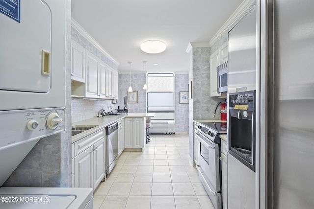 787 Ocean Ave Unit 1711, Long Branch, NJ 07740 - kitchen featuring appliances with stainless steel finishes, estacked washer and dryer, light countertops, ornamental molding, and light tile patterned floors