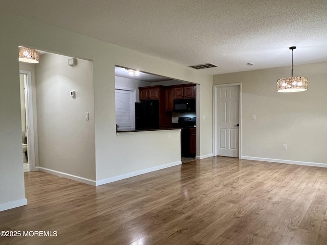 5 Lincoln Ct, Tinton Falls, NJ 07712 - kitchen with black appliances, wood finished floors, dark countertops, a chandelier, and decorative light fixtures