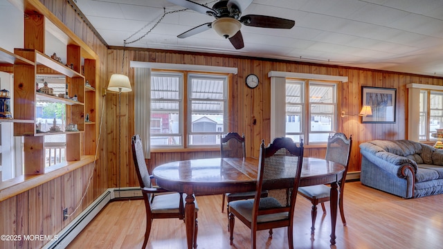 116 Hudson Ave, Hazlet, NJ 07734 - dining room featuring wooden walls, a baseboard radiator, crown molding, ceiling fan, and light wood-style flooring