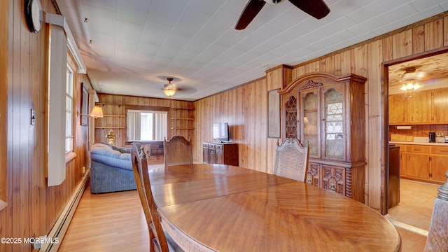 116 Hudson Ave, Hazlet, NJ 07734 - dining space featuring ceiling fan, wooden walls, a baseboard radiator, and light wood-style floors