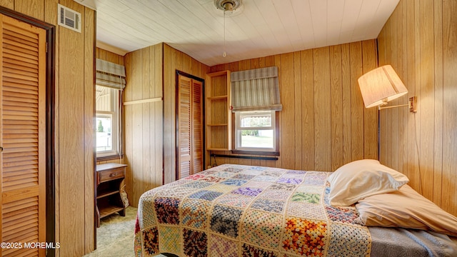116 Hudson Ave, Hazlet, NJ 07734 - bedroom featuring light colored carpet, two closets, and wooden walls