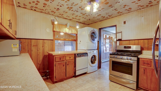 116 Hudson Ave, Hazlet, NJ 07734 - kitchen with gas range, estacked washer and dryer, white dishwasher, light countertops, and a baseboard radiator