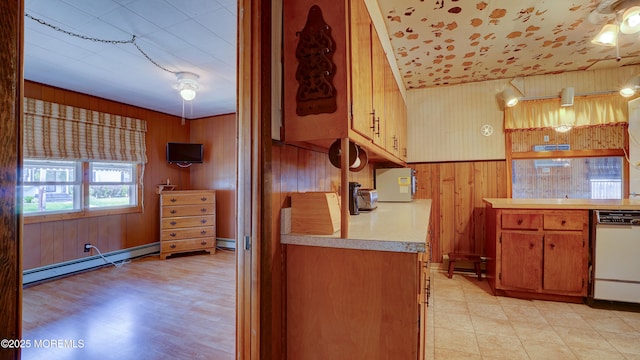 116 Hudson Ave, Hazlet, NJ 07734 - kitchen featuring white dishwasher, wooden walls, a baseboard radiator, light countertops, and brown cabinets