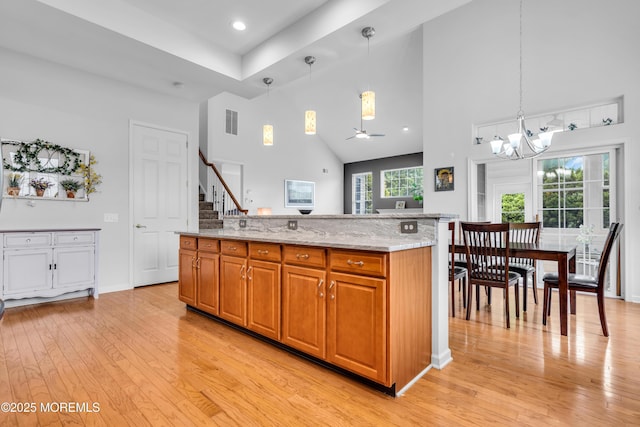 34 Shoal Rd, Jackson, NJ 08527 - kitchen featuring a high ceiling, light wood finished floors, light stone countertops, a chandelier, and brown cabinetry